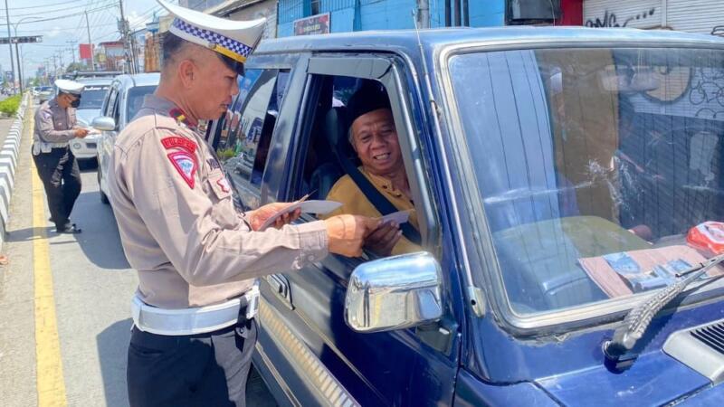 Personel Polres Tegal Kota bagikan brosur sosialisasi kesadaran berlalulintas. / Foto; Humas Polres Tegal Kota /