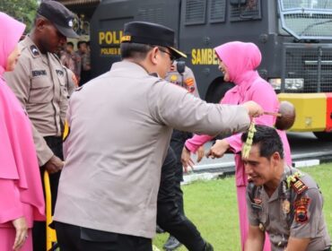 Kapolres Brebes AKBP Achmad Oka Mahendra menyiramkan air bunga kepada anggotanya yang naik pangkat. (Humas Polres Brebes)